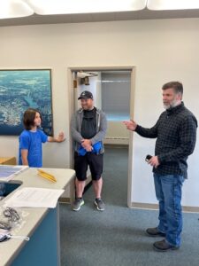Chris Paolini discusses airport operations with Arik and father, Jesse.