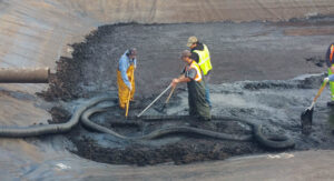 Three Port of Olympia staff work in the sediment collection pond, as part of the Port's stormwater treatment facility.
