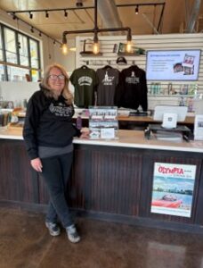 Woman standing in Olympia AHA store with merchandise in the background
